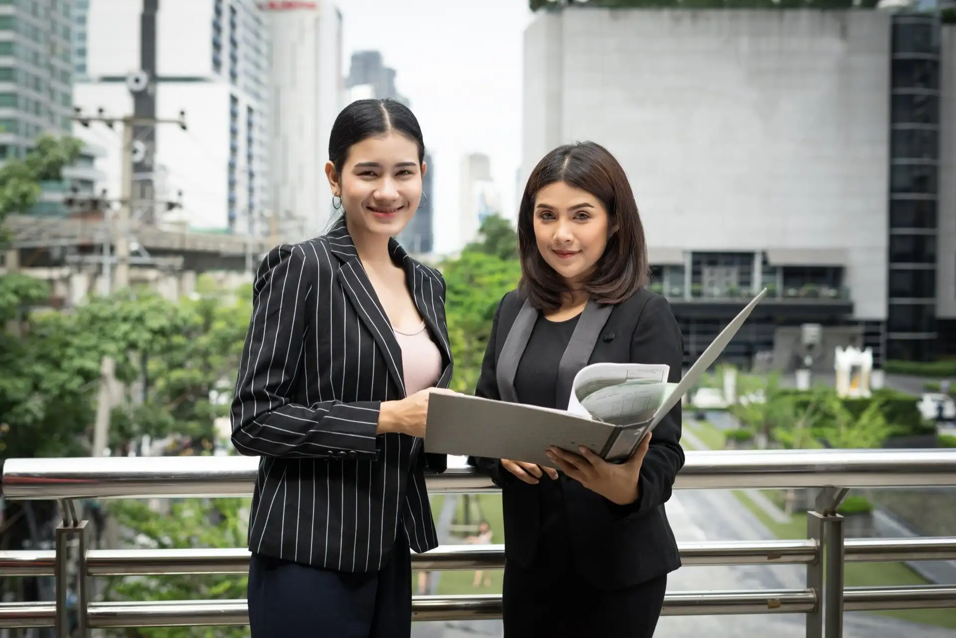 Two property sales professionals reviewing campaign results on a laptop